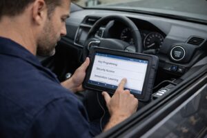 Automotive locksmith using advanced diagnostic tools to program a smart key on a modern vehicle